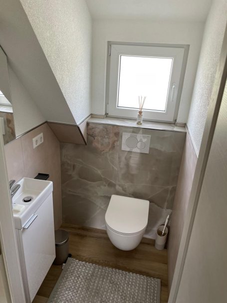 Kleines Bad mit WC, Fliesen und heller Wandgestaltung