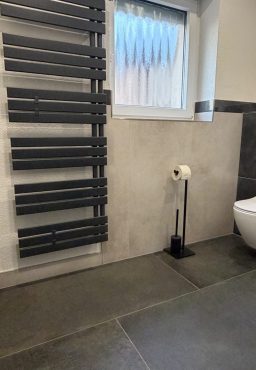 Bad mit Handtuchheizkörper Badbereich mit Handtuchheizkörper, Fliesen und WC