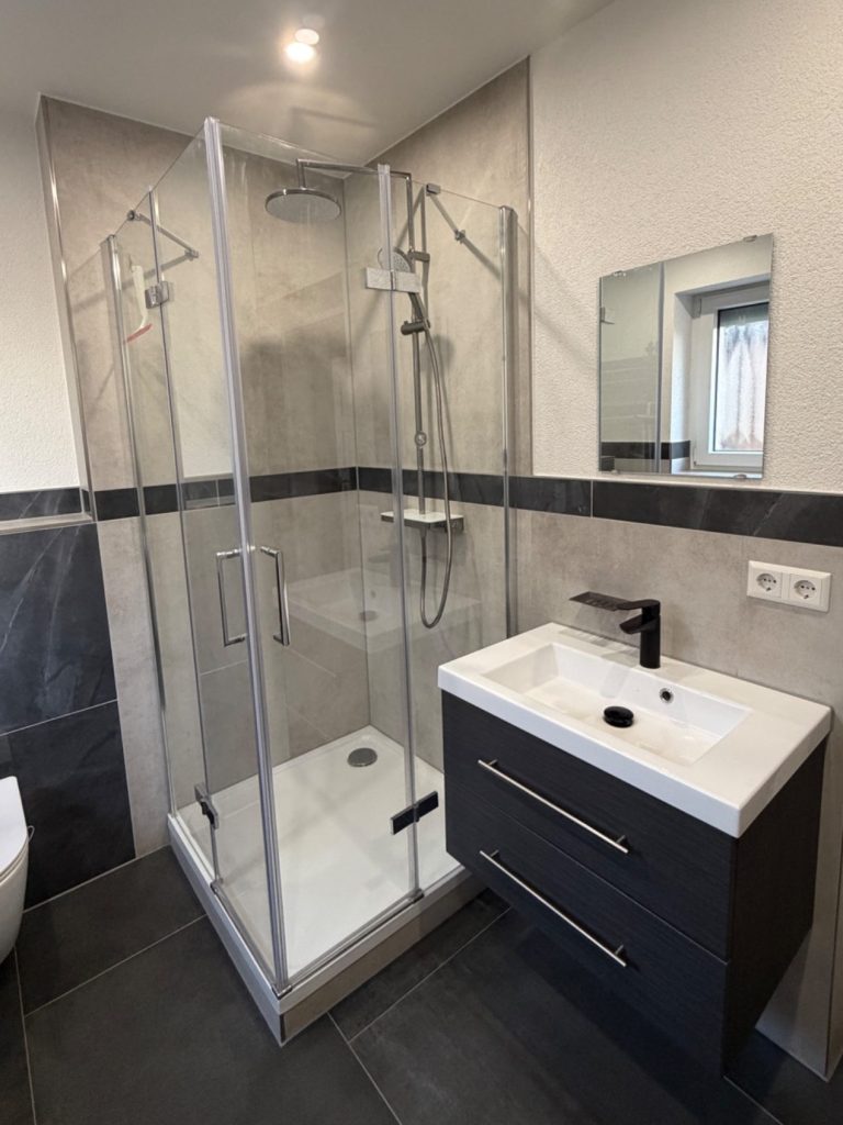 Modernisiertes Bad mit Glasdusche Modernisiertes Bad mit Glasdusche, Waschtisch und Fliesenarbeiten